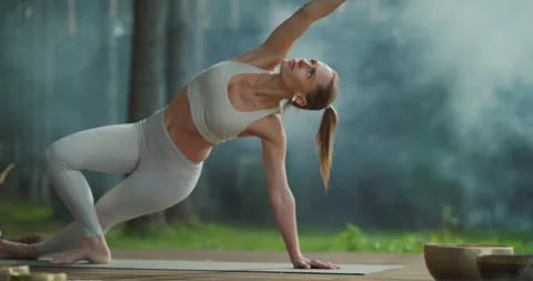 Female Making Yoga Exercise in Forest Retreat Stock Footage 296169166