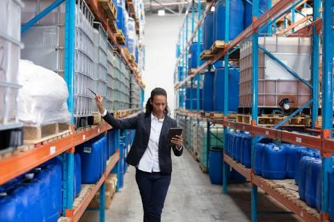 Female manager checking stocks while using digital tablet in warehouse Stock Photos