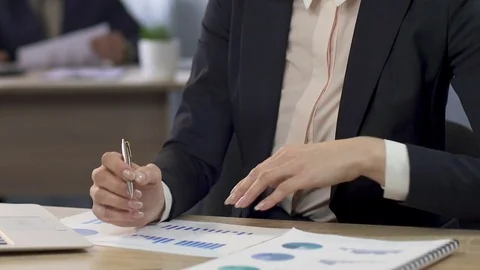 Female manager comparing two graphs and making notes at the office, business Stock Footage 79927711