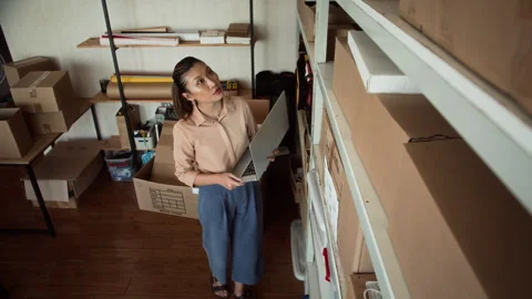 Female Manager with Laptop Checking Parcels in Storage Office Stock Footage 281718626