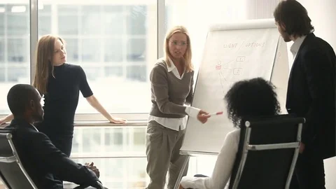 Female manager presenting new project plan to coworkers at meeting Stock Footage
