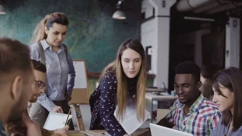 Female manager presenting the project, handing out the paper document. Business Stock-Footage 75231020