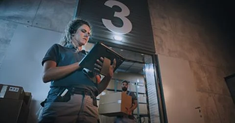 Female Manager Scanning Parcels, Using Digital Tablet. Diverse Employees Stockfoto's
