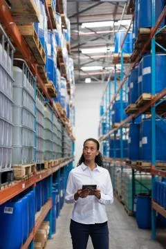 Female manager using digital tablet while checking stocks in warehouse Foto stock