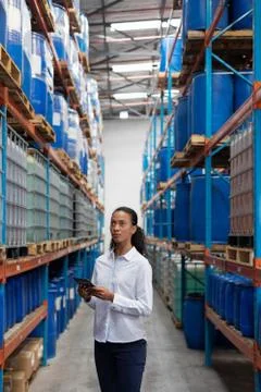 Female manager using digital tablet while checking stocks in warehouse Foto stock