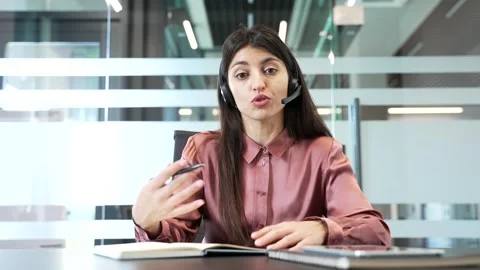 Female manager wearing headset looking at camera during online video conference, Vídeo Stock 332849495