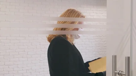 Female manager at work giving files from a colleague during coronavirus outbr 库存影片 128776636