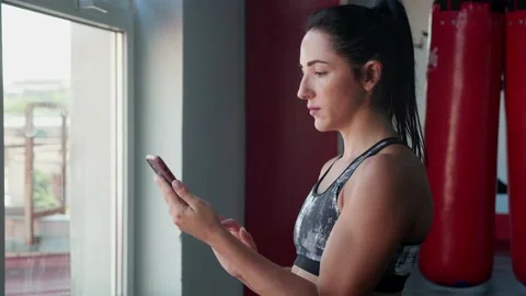 Female martial arts masterusing smart phone with personal trainer workout app in Stock Footage 165949443