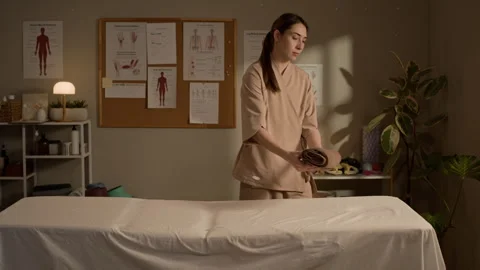 Female Massage Therapist Preparing Table with Towels Stock Footage 333673782