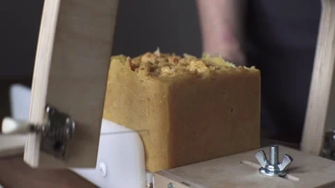 A female master soap maker cuts yellow sea buckthorn handmade soap Stock Footage 278301400