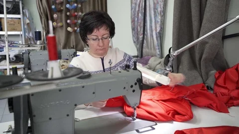 Female master tailor in making preparations for the red dress Stock Footage 126938696