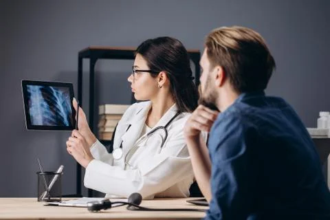 Female MD Using Tablet to Show Thorax X-ray Stock-Fotos