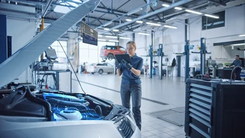 Female Mechanic Uses a Tablet Computer with an Augmented Reality Diagnostics Stock Footage 128854463