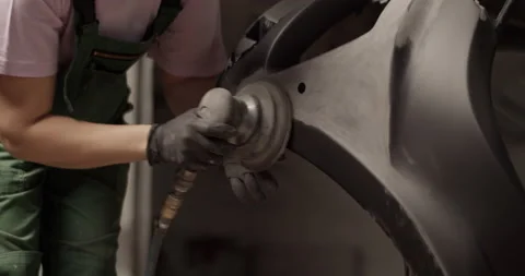 Female mechanic using sanding machine on black car bumper Stock Footage 227174994