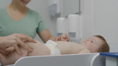 Female medic checks development of hip joints of baby Stock Footage 252633638