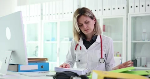 Female medic inserts documents into folder for data storage Stock Footage 285652519