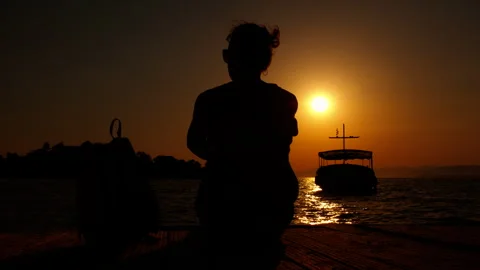 Female meets the sunset on pier Vídeos de archivo 334733073