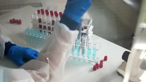Female microbiologist examines blood samples infected with a coronavirus Stock Footage 130583264