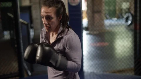 Female MMA fighter throws practice punches in the octagon Video stock 124498538