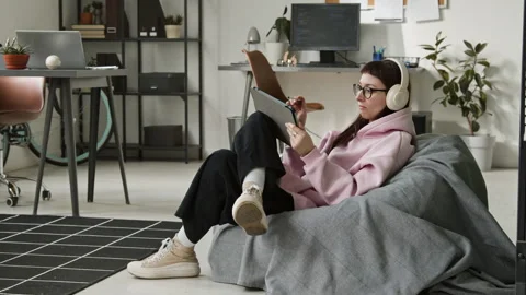 Female Mobile App Developer Working on Tablet in Bean Bag Chair in Office Stock Footage 335941462