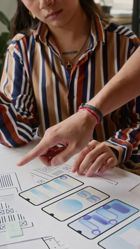 Female Mobile App Project Manager Examining Color Mockups with Male UI Designer Stock Footage 327903023