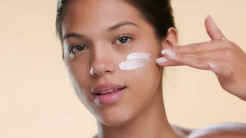 Female model applies cream on face using two fingers Stock Footage 337131981