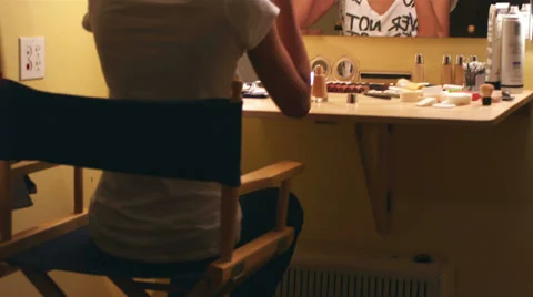 Female model applying makeup to herself while looking into a mirror Stock Footage 33839338