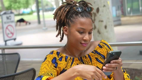 Female model checking her phone in the park Stock Footage 196834103