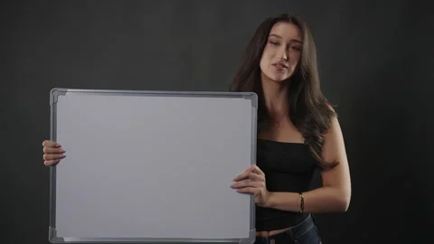 Female model holding blank white board for message or advertisement, studio shot Stock Footage 336936583