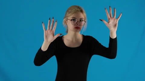 Female model in long-sleeved jacket raises hands and opens palms Video stock 306471597