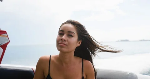 Female model looking around while riding on a speed boat Stock Footage 111423954