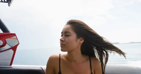 Female model looking around while riding on a speed boat Stock Footage 111424311