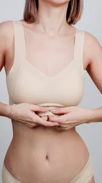 Female model posing in nude-colored seamless bra, close-up Stock Photos