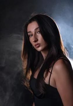 Female model posing in studio lighting with smoky background Stock Photos