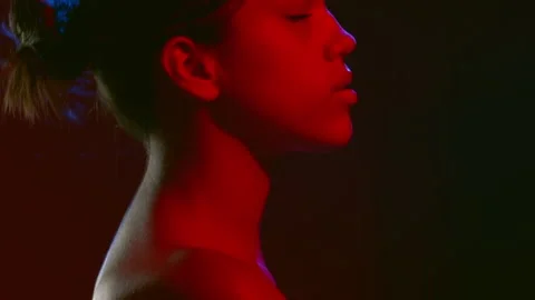 Female model in red led light sprays perfume inhales Vidéo 342566122