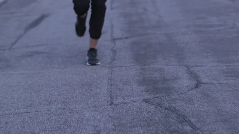 Female model running toward camera in sports bra and pants at dusk in desert Stock Footage 76722218