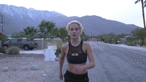 Female model running toward camera in sports bra and pants at dusk in desert 스톡 동영상 76722505