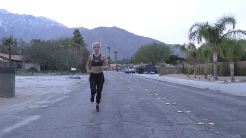 Female model running toward camera in sports bra and pants at dusk in desert 스톡 동영상 76722674