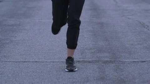 Female model running toward camera in sports bra and pants at dusk in desert Stock Footage 76722715