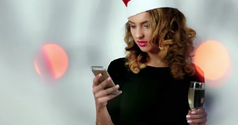 Female model is using a smarphone in a photo studio; girl wearing santa’s hat Stock Footage 62321746