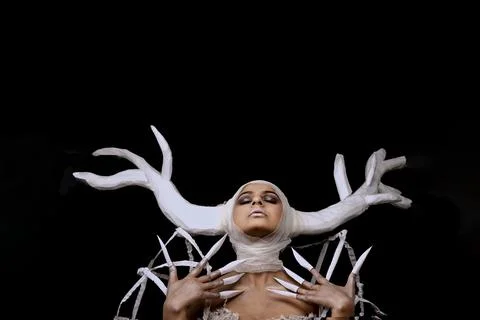 A female model in a white gown wearing a white reindeer crown Stock Photos