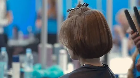 Female model whith basic bob getting hair straightened by hairdresser closeup on 스톡 동영상 69072589