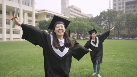 Female mortarboard fall down on grass in campus 库存影片 108663071
