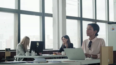 Female multi-ethnic manager working in office with laptop and smiling. In the Stock Footage 124549219