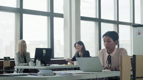 Female multi ethnic manager works in office with laptop and communicates with Stock Footage 124272586