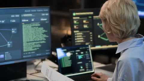 Female Network Engineer Analyzing Document and Coding on Computers in Office 動画素材 334934179