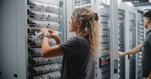 Female Network Engineer Connecting Ethernet Patch Cables in Data Center Stockbeeldmateriaal 344955144