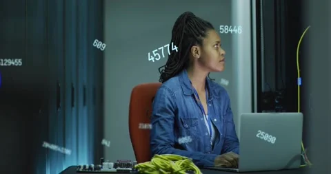 Female network engineer typing on laptop, causing numeric overlays and checking Stock Footage 334182735