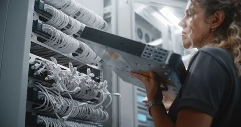 Female Network Technician Installing Active Switch Hardware in Server Rack 動画素材 344970152