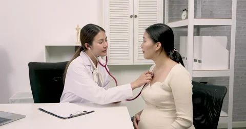 Female obstetrician gently using stethoscope to check heartbeat of Asian 動画素材 329660603